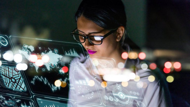 Ingeniera con gafas en su escritorio observando software en su computadora portátil