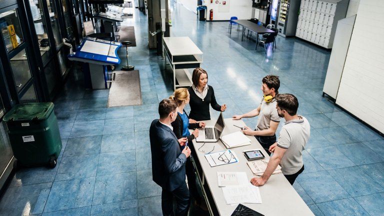 Workers and executives collaborating in a factory