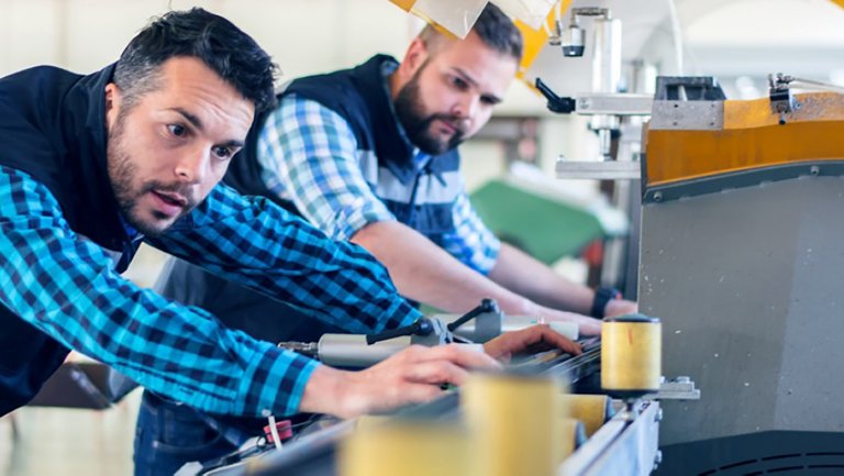 Two men observing production line using Plex QMS