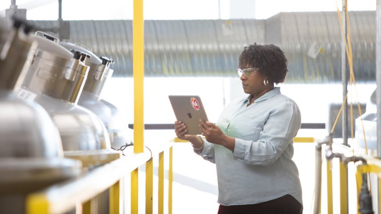 Woman worker looking at a tablet in a factory setting