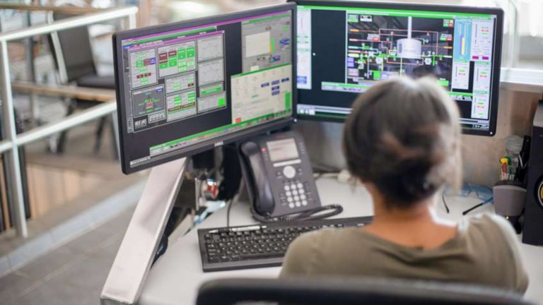 Female employee reviewing a real-time view of operations with FactoryTalk Site Edition