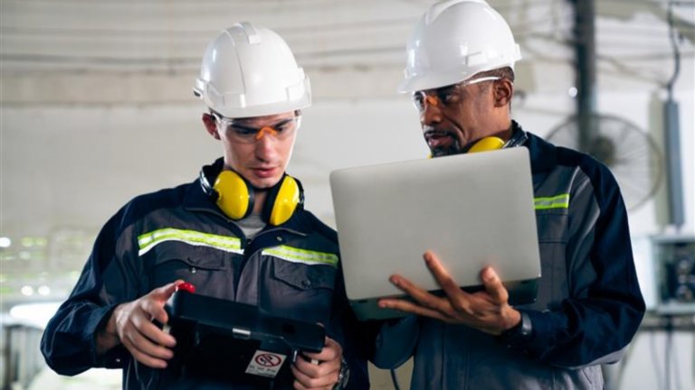 engineer holding device working with engineer holding laptop
