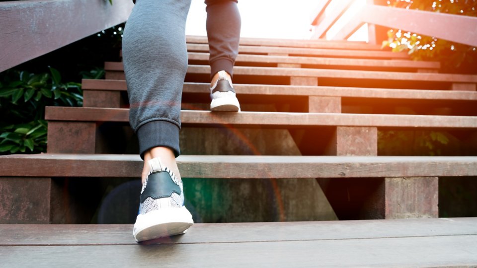 Close up of legs and feet of a person climbing stairs
